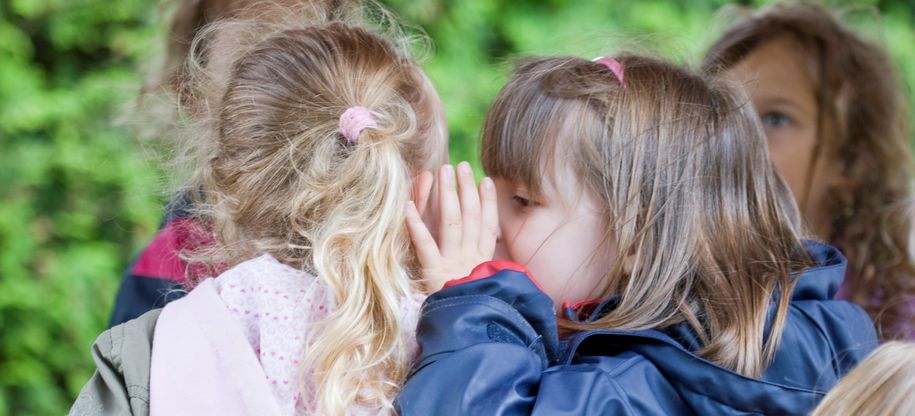 Barn hvisker og snakker sammen