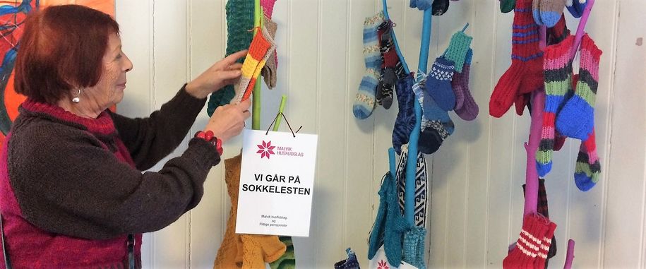 Bilde av Britt Ragna Renanger foran 80 par strikkede strømper