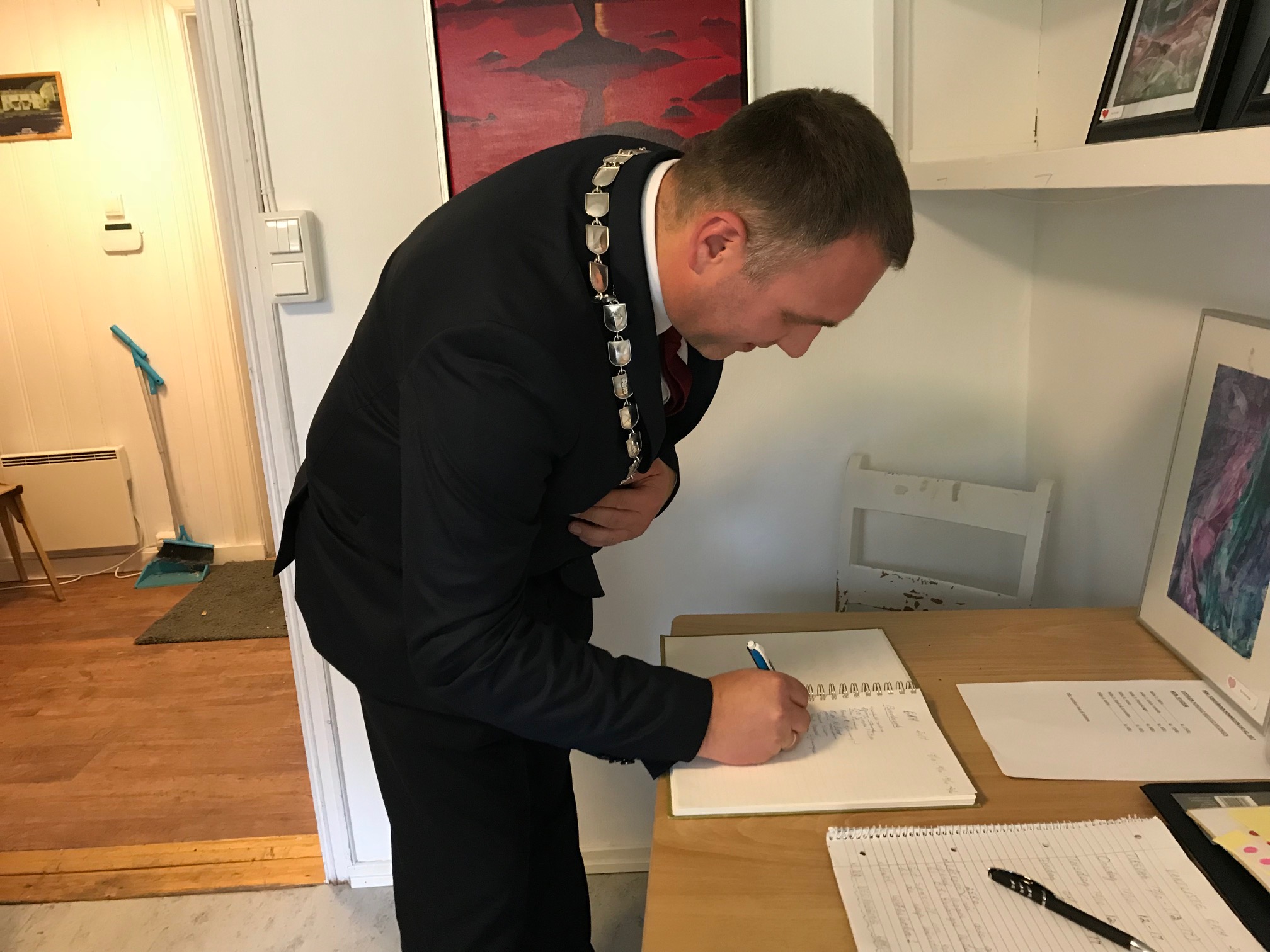 Bilde av varaordfører Ole Herman Sveian som signerer besøksprotokollen