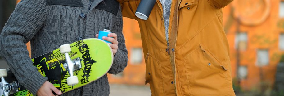 Bilde av to ungdommer med skateboard og sprayboks