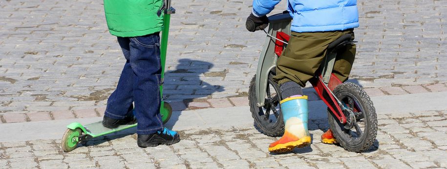 NataliaL Illustrasjonsbilde av to gutter. Den ene har sparkesykkel, og den andre har sykkel.