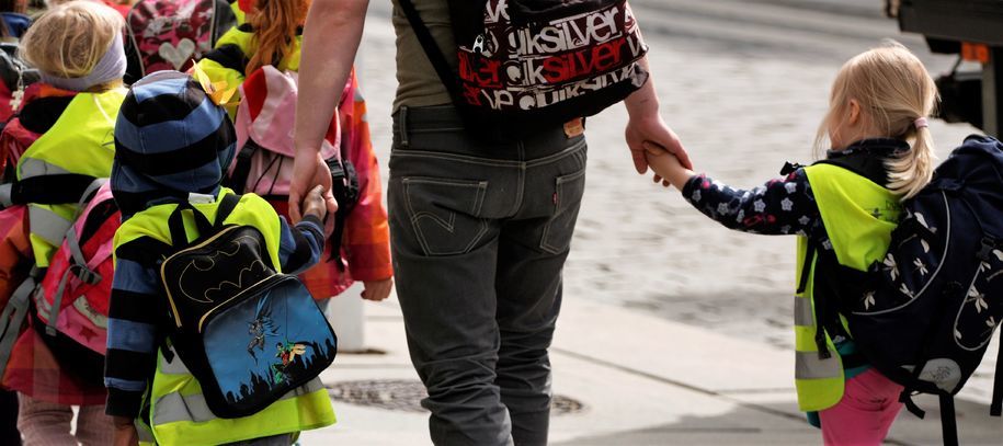 Illustrasjonsbilde av barn på veg til skolen som holder hender