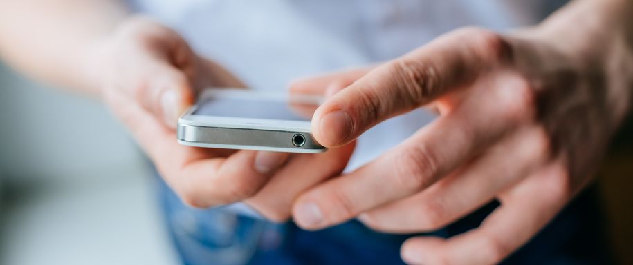 Bilde av hender som holder mobiltelefon