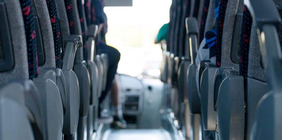 Bilde fra innsiden av buss med midtgang og seter
